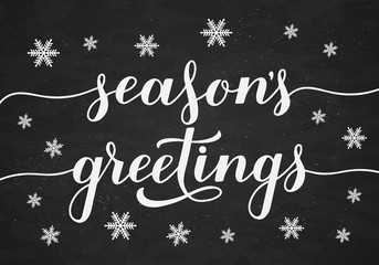 Season s Greetings calligraphy hand lettering on chalkboard background with snowflakes. Christmas and New Year typography poster. Easy to edit vector template for greeting card, banner, flyer, etc.