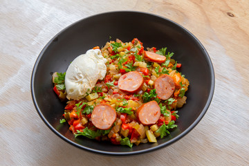 Spanish dish pisto manchego with chorizo sausages and poached egg