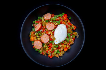 Spanish dish pisto manchego with chorizo sausages and poached egg