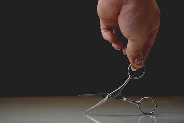 hand with  dirty scissors on the floor 