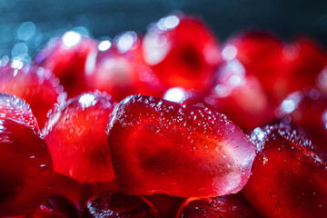 Ripe pomegranate seeds closeup on a dark background. Spectacular macro photo. The concept of...