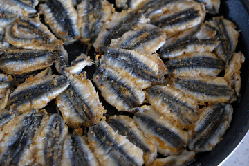 anchovy fish cooked on a stove, cooking anchovy in a pan, anchovy in a Turkish style pan,