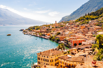 Limone Sul Garda cityscape on the shore of Garda lake surrounded by scenic Northern Italian nature. Amazing Italian cities of Lombardy - obrazy, fototapety, plakaty