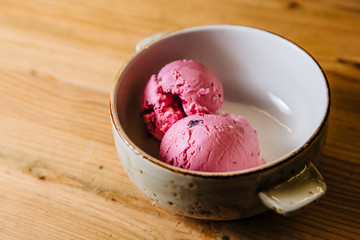 Ice cream in bowl on a wooden table.