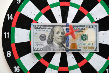 100 us dollar and dart arrows, dart board and 100 usd dollar,