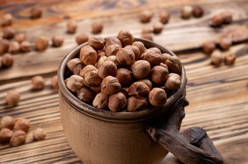 hazelnuts in a decorative cup on wooden boards close-up