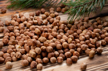 roasted hazelnuts on wooden boards close-up and Christmas trees in the background