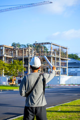 Engineer who is see plan to oversee construction site