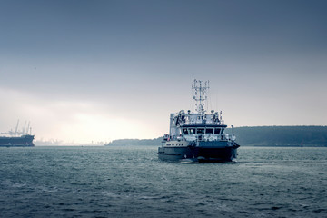 Commercial vessel goes to sea in cloudy weather