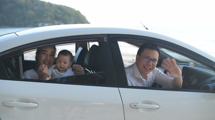 Holiday concept. The family waved goodbye inside the white car on the beach. 4k Resolution.