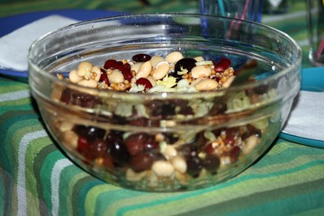 a large glass container full of mixed bean salad
