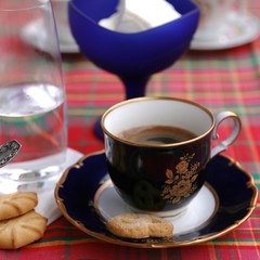 Ice cream in blue glass cup, coffee cup and clean water glass on the table