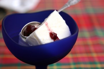 Cold ice cream in cups dark blue, teaspoon, raspberry jam