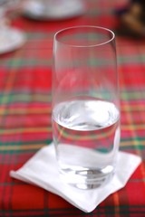 Glass with clean cold water on white napkin