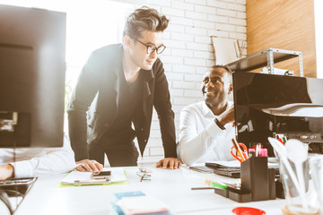A team of young businessmen working and communicating together in an office. Corporate businessteam and manager in a meeting.