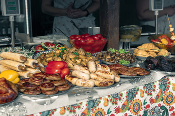A lot of cooked food on the table. Grilled food. Food market