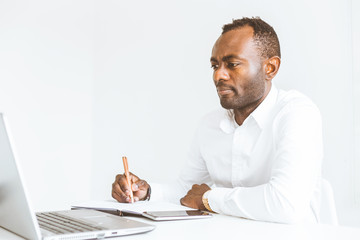 Young african American businessman working in the office at the laptop