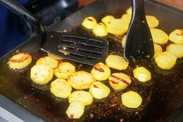 Potatoes cut to small circles, seasoned with spices, grilled on electric grill