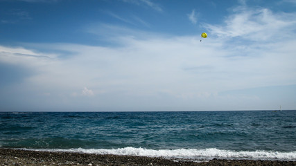 yellow parachute with a smile on a background of blue sea and sky