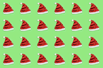 Red Sparkling Santa Claus Hat on green background. Christmas pattern. Photo collage background