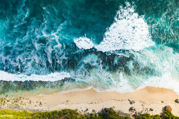 View from above, stunning aerial view of a rocky shore with a beautiful beach bathed by a rough sea...
