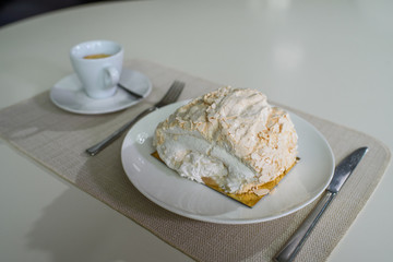 A delicious roll of bezrukov and a cup of coffee on a table in a cozy coffee shop