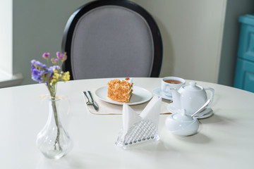 Delicious carrot cake and a cup of black tea on the table in a cozy coffee shop