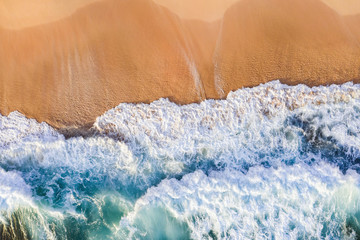 View from above, stunning aerial view of some waves crashing onto a beautiful beach during sunset. Nyang Nyang Beach (Pantai Nyang Nyang), South Bali, Indonesia.