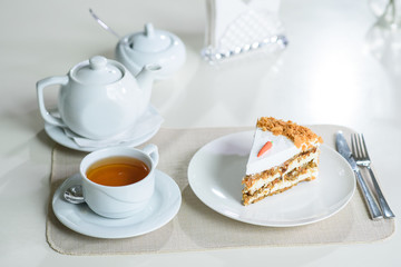 Delicious carrot cake and a cup of black tea on the table in a cozy coffee shop