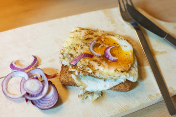 fried egg sandwich on wooden plate