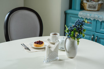 Danish with cherries and black tea on a table in a cozy coffee shop