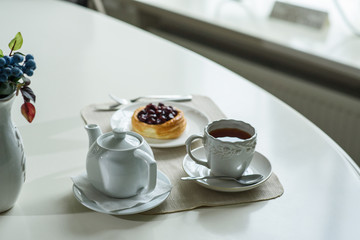 Danish with cherries and black tea on a table in a cozy coffee shop