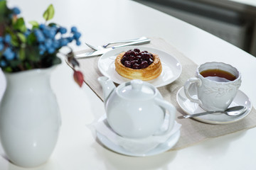 Danish with cherries and black tea on a table in a cozy coffee shop