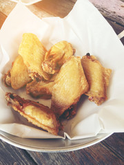 Deep fried chicken wing with garlic sauce in bucket. on wooden table for asian food concept. Thai style food.
