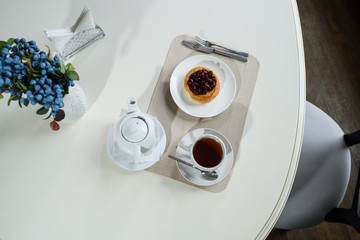 Danish with cherries and black tea on a table in a cozy coffee shop