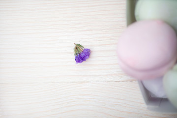 a small purple flower on a white table and a blurred French marshmallow