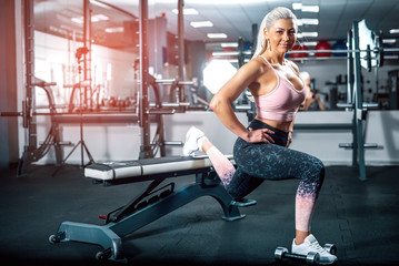 Woman doing lunge with dumbbells.