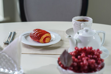 Cake with strawberries and black tea on the table in a cozy coffee shop