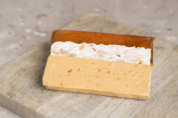 Three type of  Spanish turron, hard almond, soft almond and burnt egg yolk nougat on wooden background. Traditional Christmas sweet.