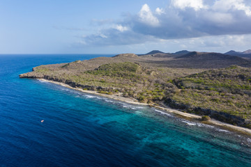 Aerial view of coast of Curaçao in the Caribbean Sea with turquoise water, cliff, beach and beautiful coral reef around Sta. Martha Bay