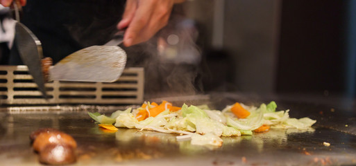 Japanese chef cooking meat in teppanyaki restaurant