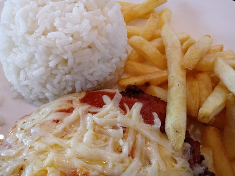 Close Up Meal With Chicken Parmigiana Steak, White Rice And Chips