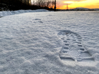Footprints texture close up on white snow to go forward when sunrise in winter season.