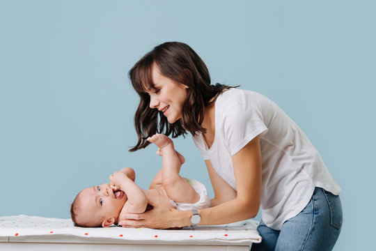 mother bent over her infant talking, caring and playing with him