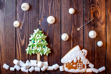 gingerbread sweet house, next to a sweet Christmas tree, below is sweet snow on the background of a shooting star and snow on a wooden background