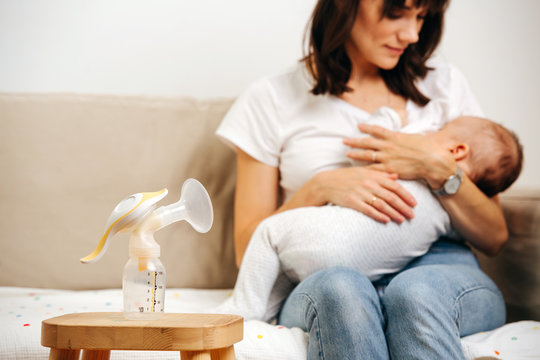 Mom gently looks at the baby and breastfeeds