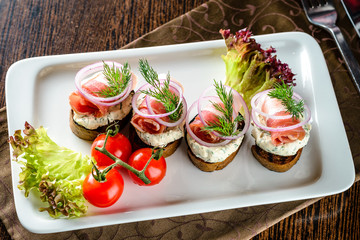 Salted lard and salted bacon with black bread, garlic, onion and horseradish sauce on a wooden board
