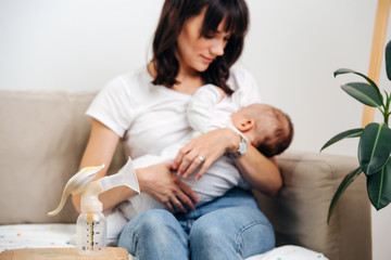 Mom gently looks at the baby and breastfeeds