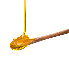 Falling and flowing honey on a wooden spoon isolated on white with clipping path