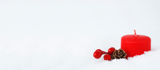 Christmas composition of red candle, cones and branches of red berries isolated on a white snow covered background. Christmas, New Year's concept. close-up. Copy space